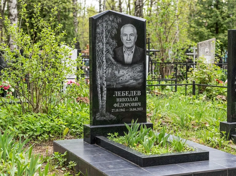 Памятник с гравировкой берёзы: вертикальная стела со скошенным верхом — берёза и стая птиц в небе, гранитный цоколь с тёмной плиткой, работа «Лебедев» в Санкт-Петербурге