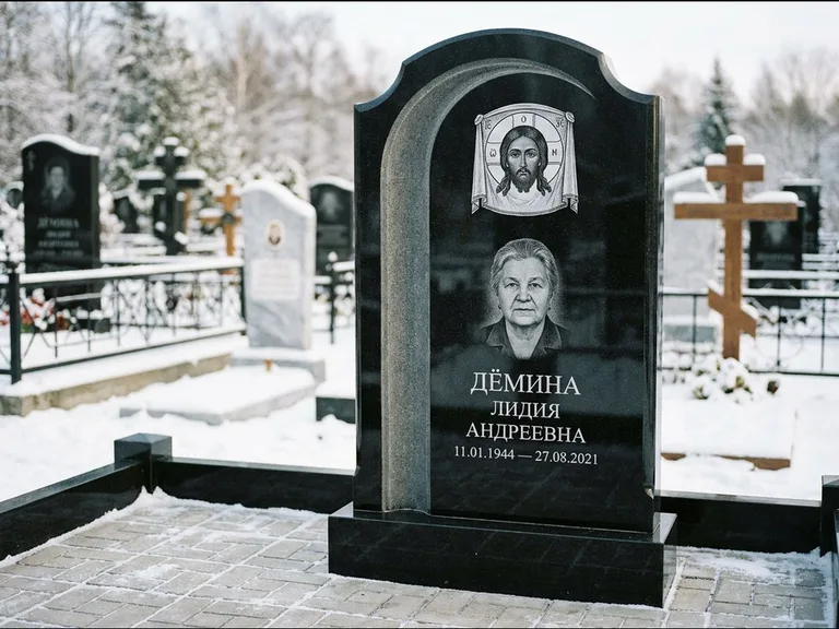 Памятник с гравировкой иконы: гранёный восьмиугольный обелиск с крестом — гравировка Николая Чудотворца, семейный участок с гранитной скамьёй, работа «Зотов» в Санкт-Петербурге