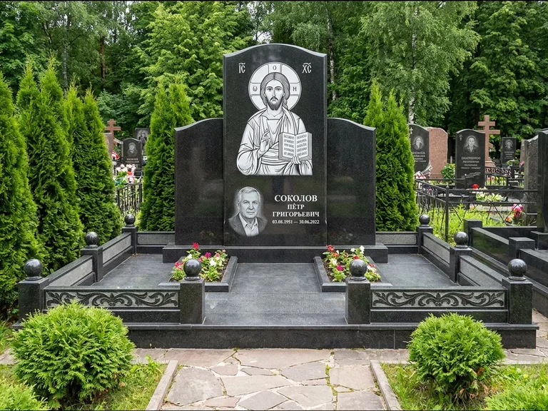 Памятник с гравировкой иконы: широкая горизонтальная лежачая плита-стела — икона в резной рамке-киоте, серая гравийная отсыпка с бордюром, работа «Богданова» в Санкт-Петербурге