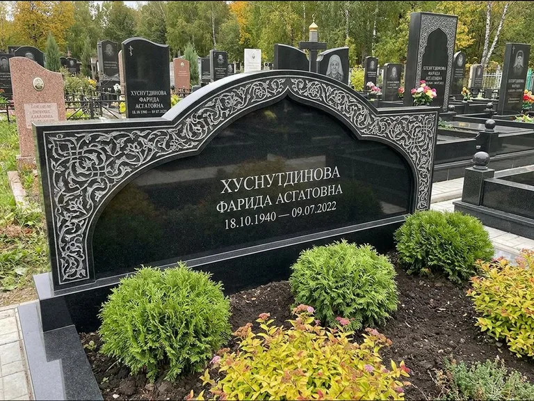 Мусульманский памятник: вытянутая горизонтальная семейная стела с аркой — белая гравировка силуэта мечети с минаретами, участок с декоративными кустами, работа «Зарипова» в Санкт-Петербурге