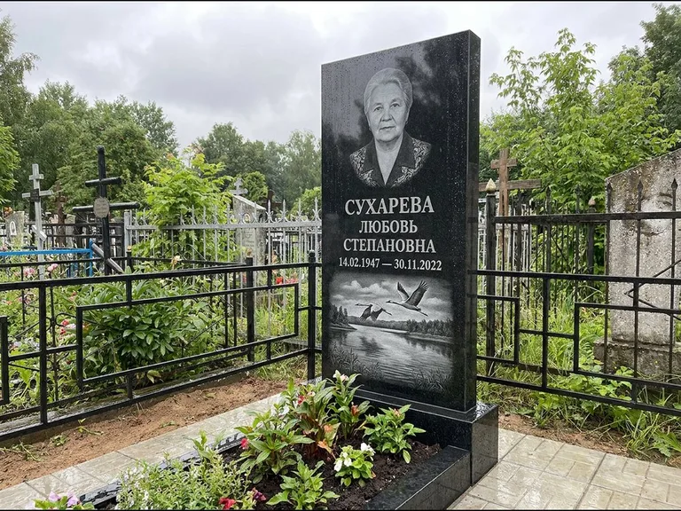 Памятник с гравировкой журавлей — гравировка пары журавлей над гладью озера в нижней части, работа «Сухарева» в Санкт-Петербурге